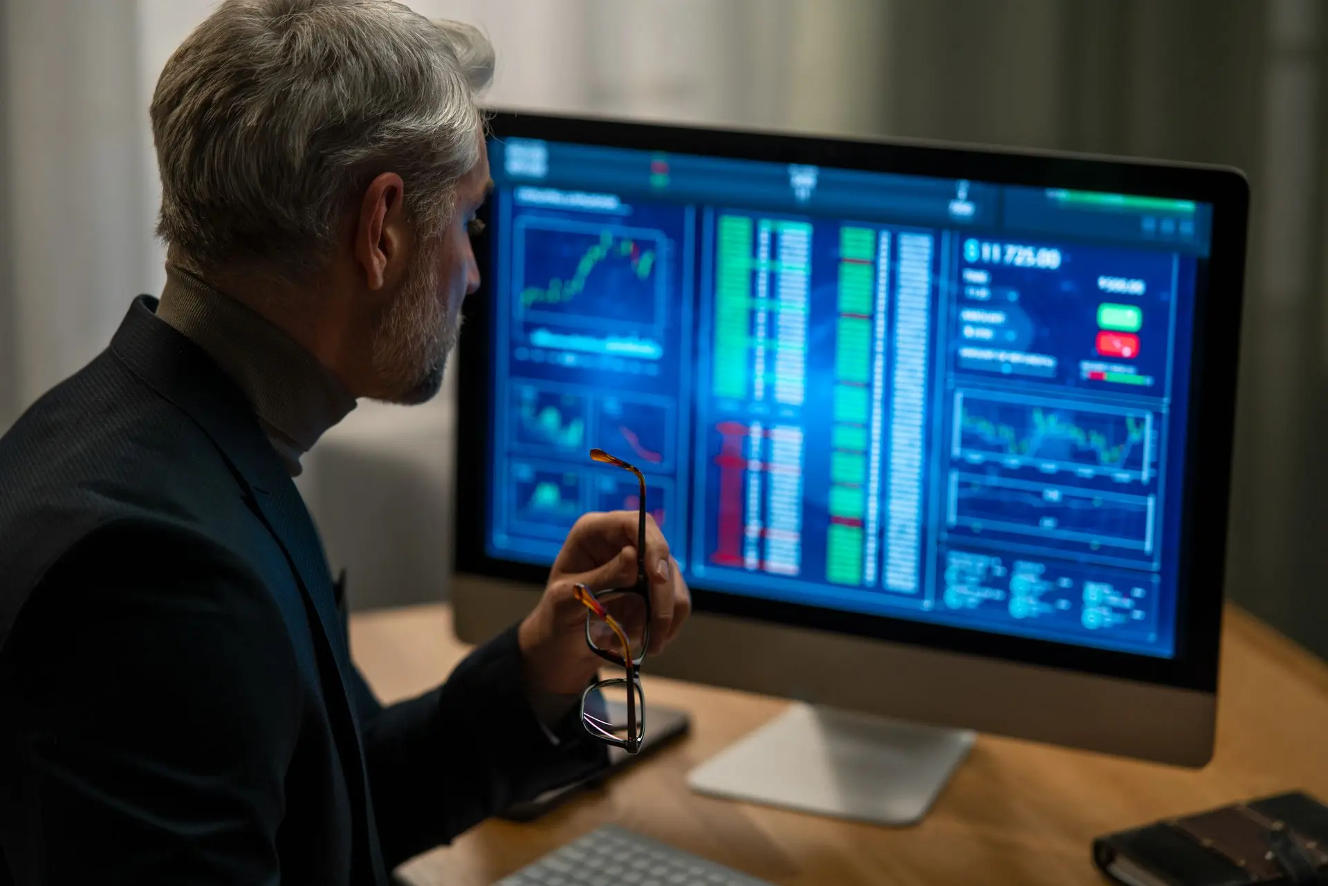 Empresario analizando los mercados en varios monitores de su oficina