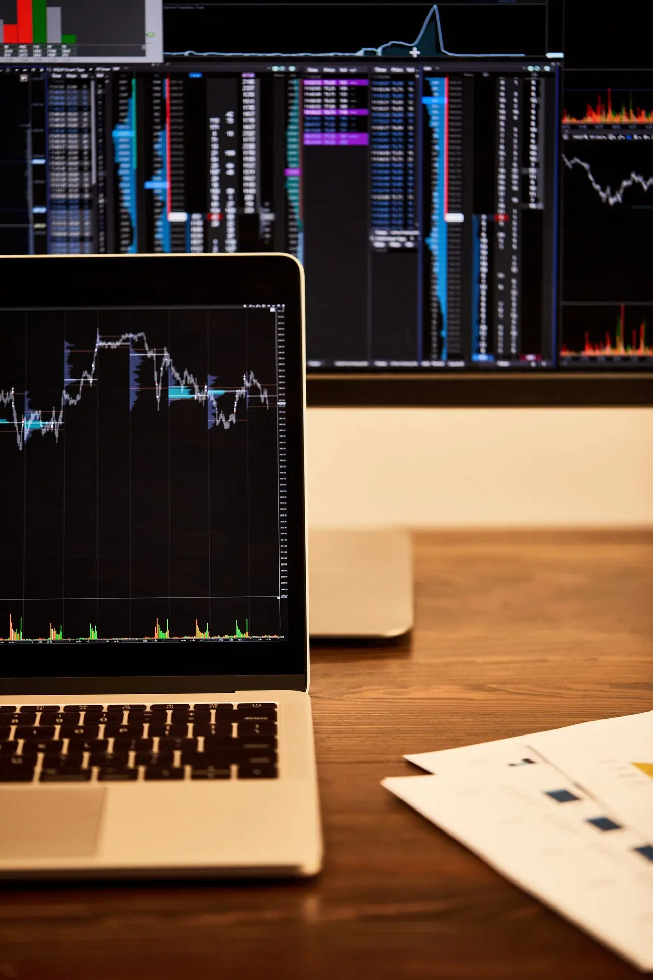 Pantallas de laptop y computadora con cuadros y gráficos financieros