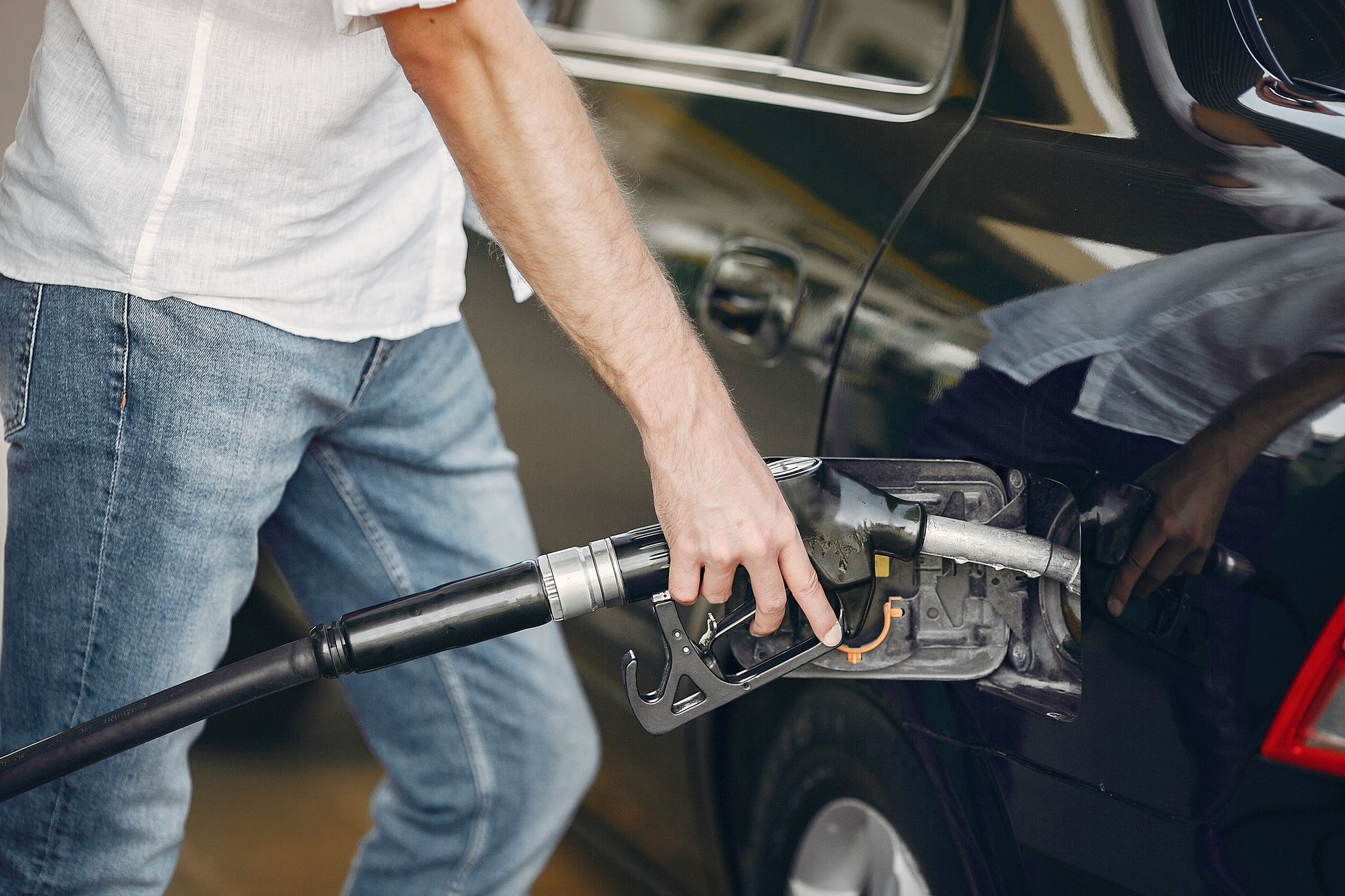 Persona cargando gasolina en el tanque de un automóvil